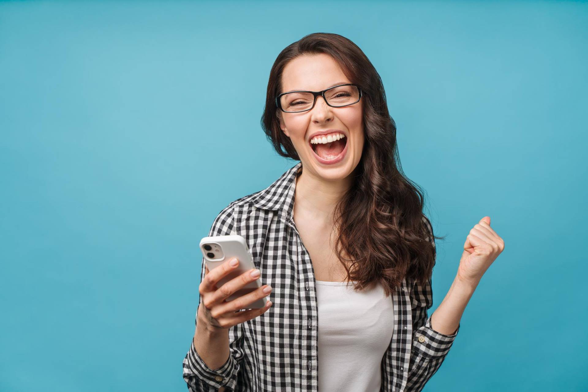 Imagen de una mujer feliz sujetando su smartphne